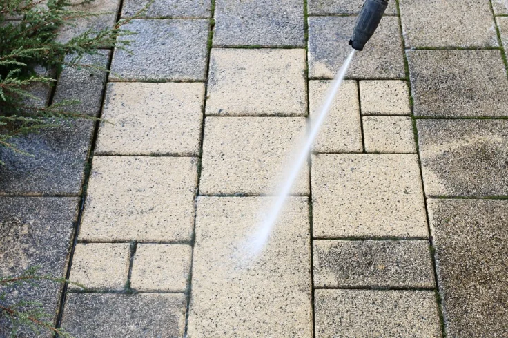 Surface pressure washing cleaning dirt from outdoor pavers